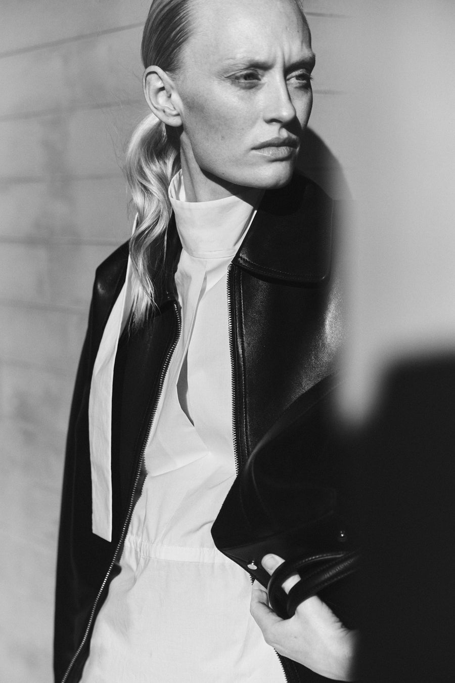 Luca wears the Vroman Leather Jacket in Black, the Ezra Dress in Parchment & carries the Ellis Bag in Black