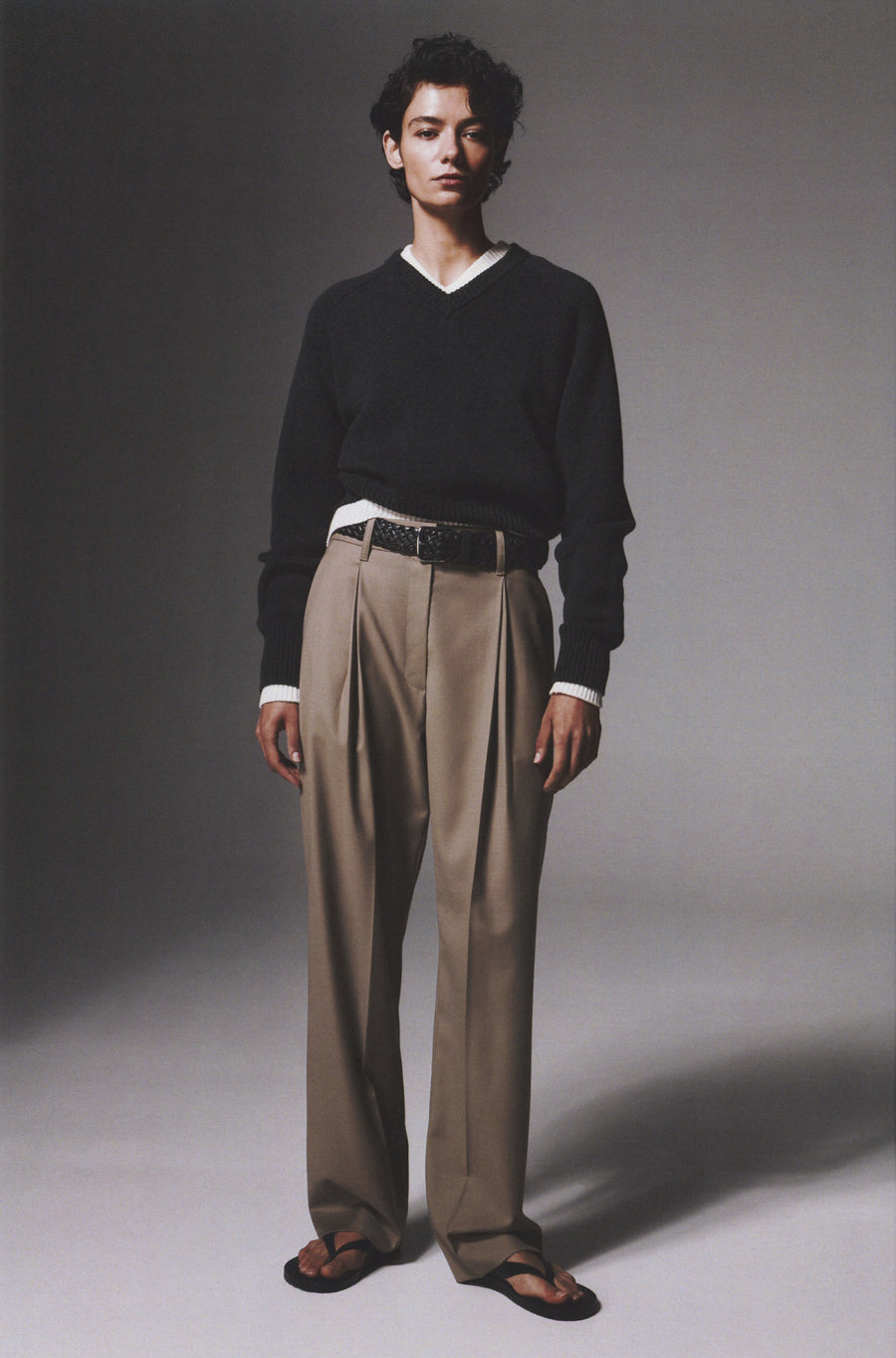 Anna Lee wears the Diot Knit in Oyster and Charcoal Melange layered with the Goddard Straight Pant in Pumice and the Flora Sandal.