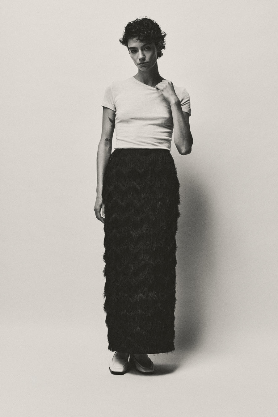 Anna Lee wears Innes Skirt in Black Fringe with the Hendry Top & Lane Loafer