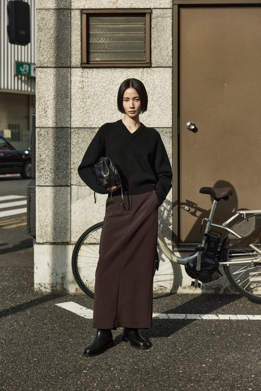 Tsugumi wears the Diot Knit, Adrien Skirt, Jude Knee High Boot and Tobey Bag.