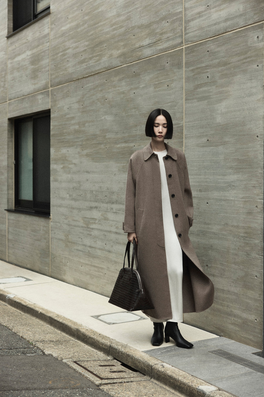 Tsugumi wears the Daniels Coat over the Sisco Dress with the Tones Knee High Boot & Harnick Bag in Bistre Embossed Croc.