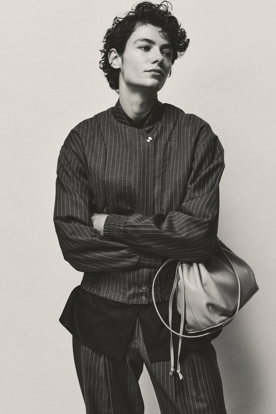 Anna Lee wears the Giles Bomber and Goddard Straight Pant in Charcoal Pinstripe with the Seth Shirt and Tobey Bag.
